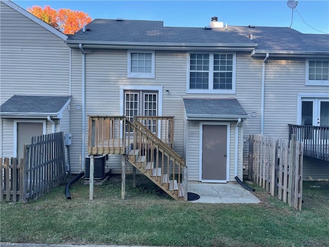 back of house featuring central AC, a deck, and a lawn