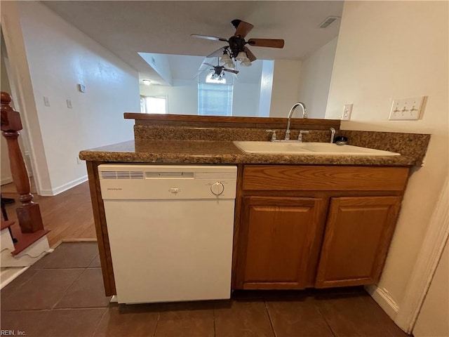 kitchen featuring kitchen peninsula, sink, white dishwasher, and dark tile patterned flooring