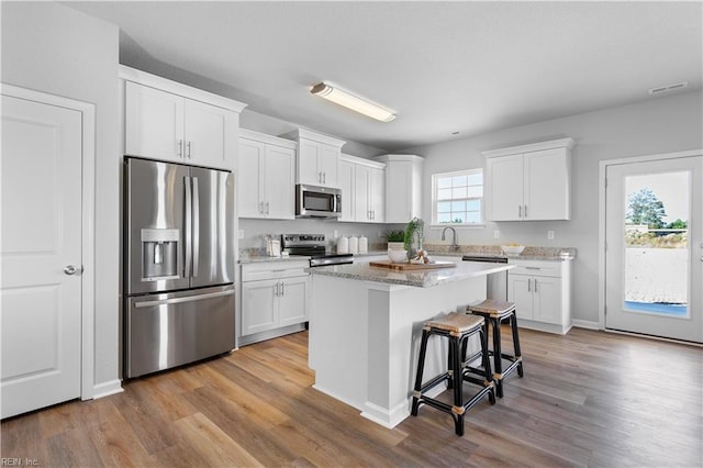 kitchen featuring a wealth of natural light, white cabinetry, and stainless steel appliances