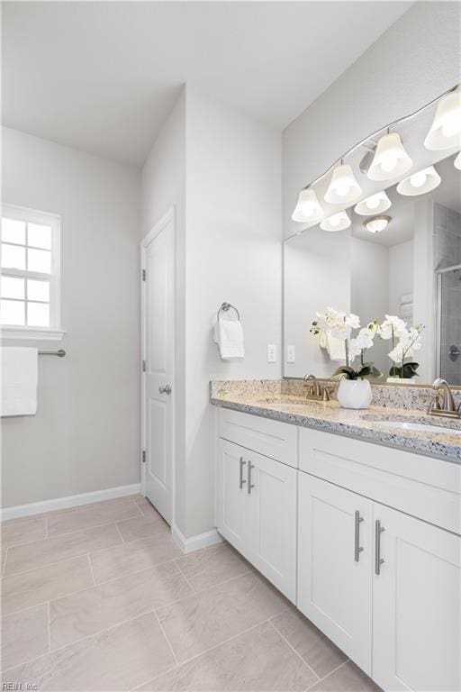 bathroom featuring a shower with door, vanity, and tile patterned flooring