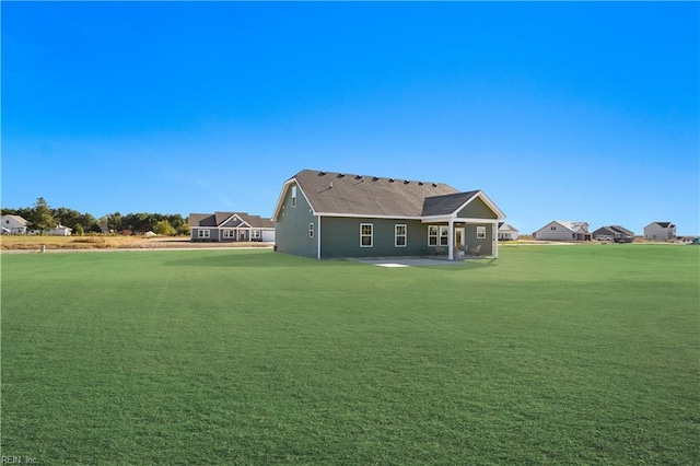 rear view of property with a patio and a lawn