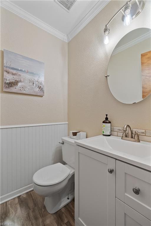 bathroom featuring toilet, crown molding, hardwood / wood-style flooring, and vanity