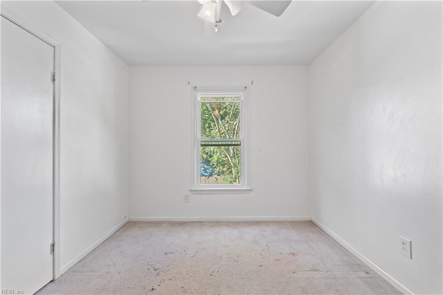 carpeted spare room featuring ceiling fan