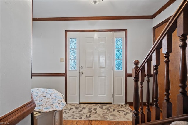 foyer entrance with hardwood / wood-style floors, crown molding, and a healthy amount of sunlight