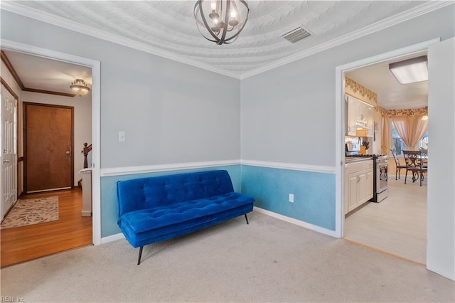 living area with light carpet, ornamental molding, and an inviting chandelier