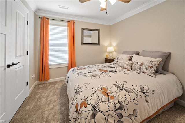 carpeted bedroom with ornamental molding and ceiling fan