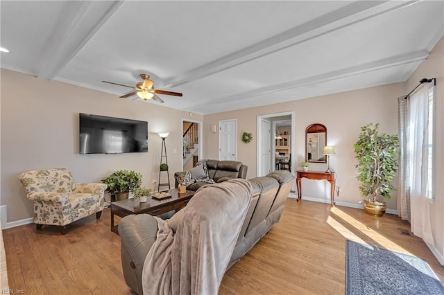 living room with a wealth of natural light, light hardwood / wood-style floors, and beam ceiling