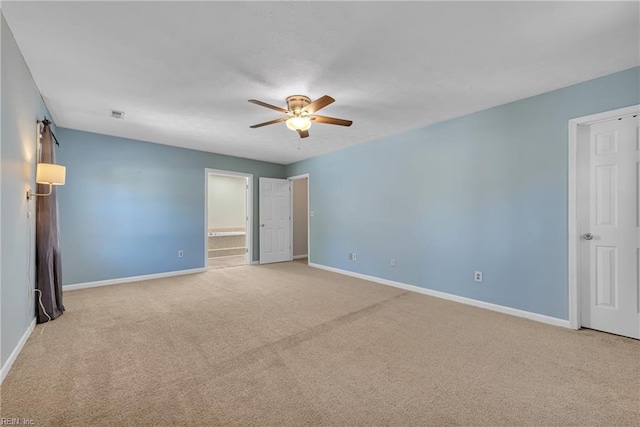 spare room featuring light carpet and ceiling fan