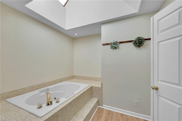 bathroom featuring a relaxing tiled tub and hardwood / wood-style floors