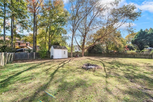 view of yard with a shed and an outdoor fire pit