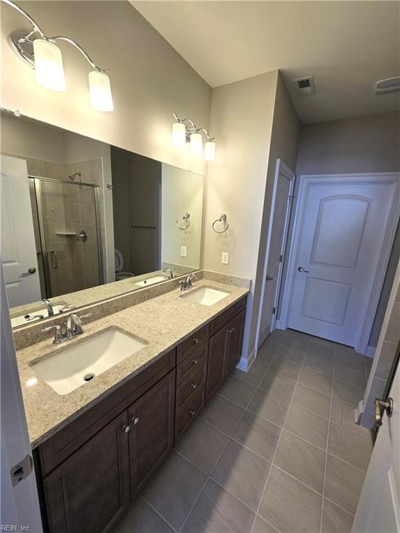 bathroom with tile patterned floors, vanity, and walk in shower