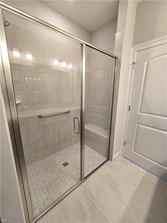 bathroom featuring tile patterned floors and a shower with shower door