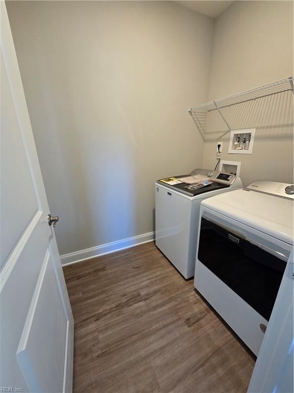 washroom with hardwood / wood-style flooring and washing machine and clothes dryer