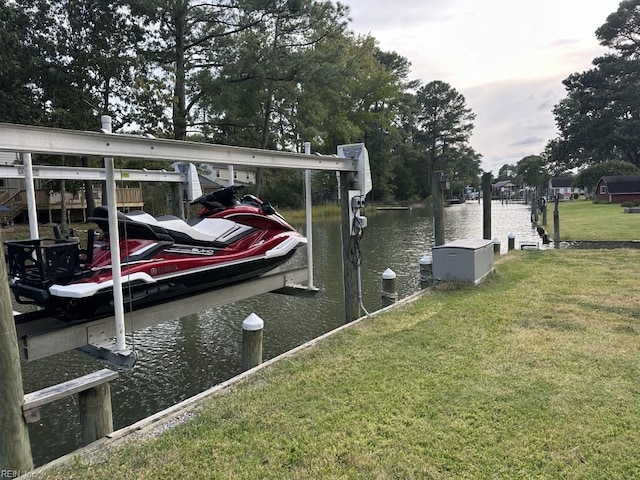 view of dock with a yard and a water view