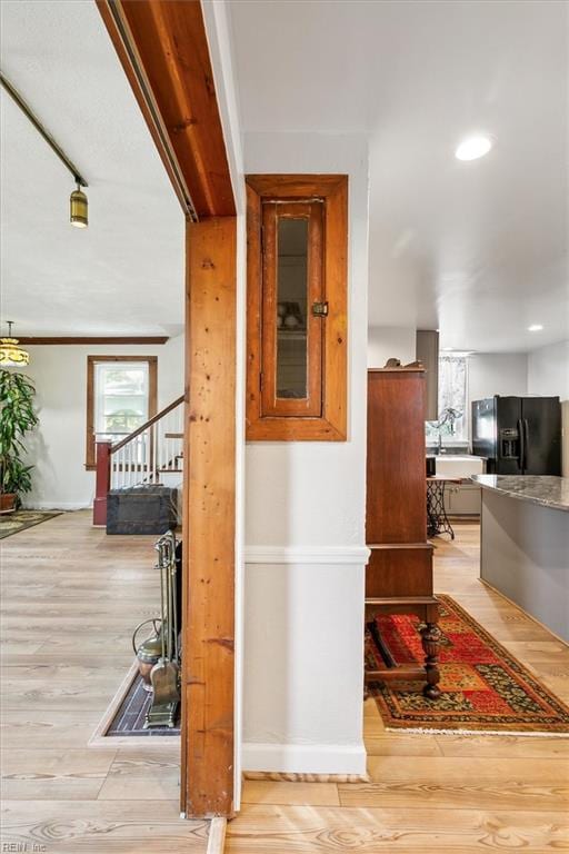 hallway featuring ornamental molding and light hardwood / wood-style flooring