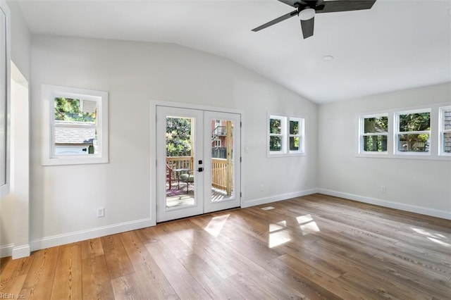 empty room with french doors, hardwood / wood-style flooring, ceiling fan, and vaulted ceiling