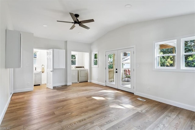 interior space featuring french doors, a healthy amount of sunlight, light wood-type flooring, and washing machine and clothes dryer