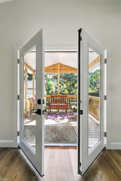 doorway to outside with lofted ceiling, dark wood-type flooring, and french doors