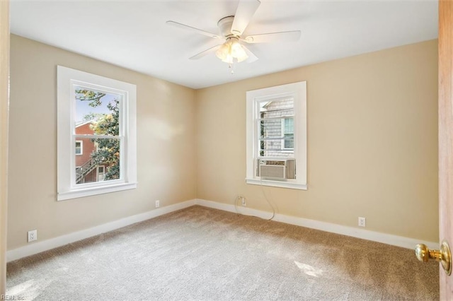 spare room featuring a wealth of natural light, cooling unit, carpet flooring, and ceiling fan