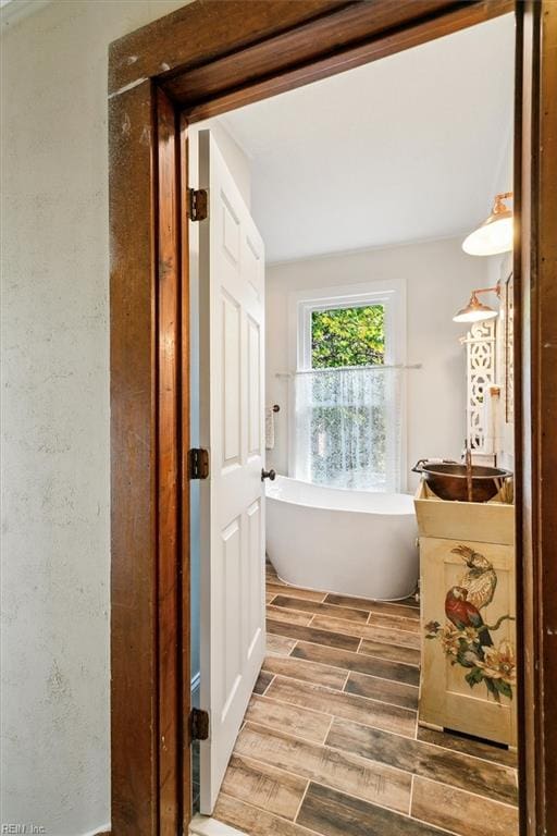 bathroom with a bathtub and wood-type flooring