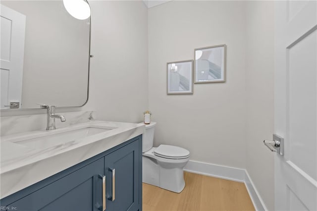 bathroom featuring vanity, wood-type flooring, and toilet