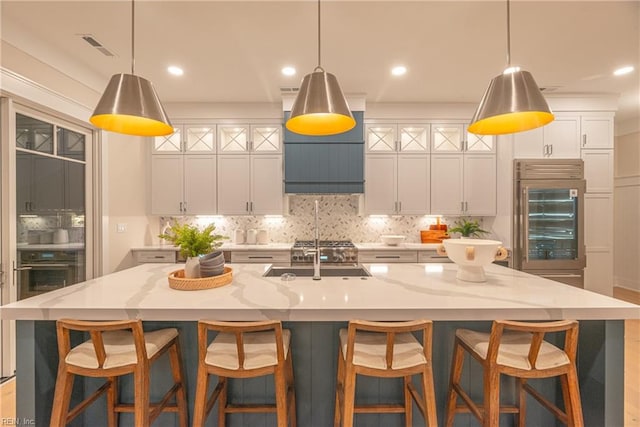 kitchen featuring a large island, light stone countertops, and pendant lighting