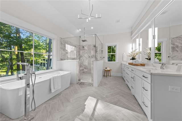 bathroom with vanity, a notable chandelier, plus walk in shower, and a wealth of natural light