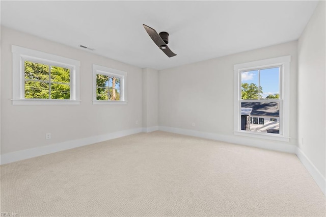 empty room with ceiling fan, a healthy amount of sunlight, and carpet