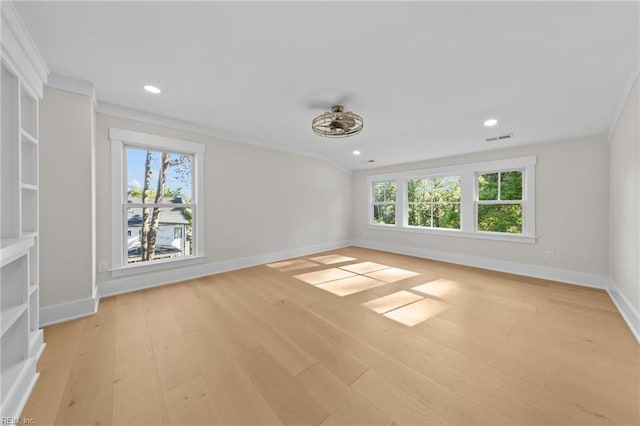 spare room featuring crown molding, light hardwood / wood-style flooring, and plenty of natural light