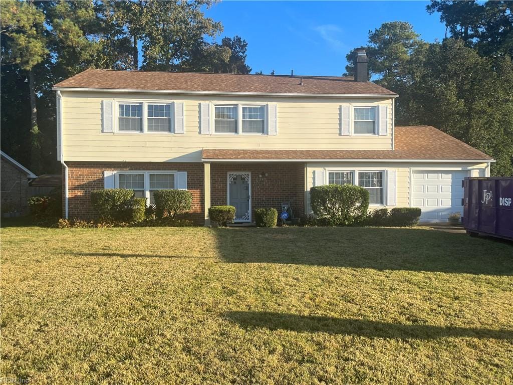 view of front of property with a front yard and a garage