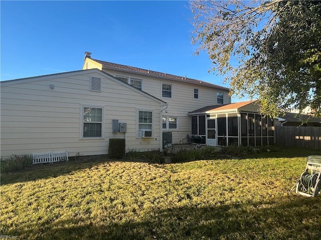 rear view of property with a sunroom and a lawn