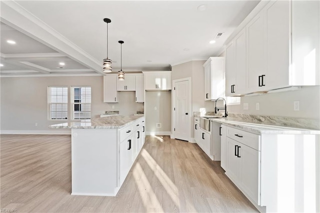 kitchen with pendant lighting, light wood-type flooring, a kitchen island, and white cabinets