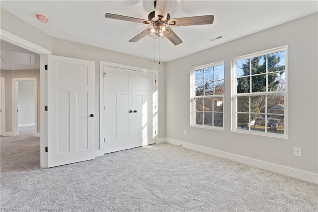 unfurnished bedroom featuring light carpet, a closet, and ceiling fan