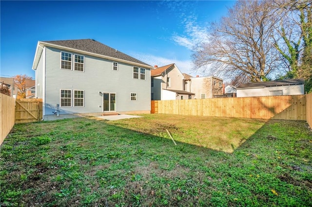 rear view of property featuring a patio and a yard