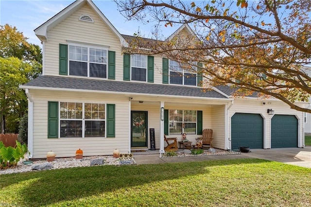 view of front of property featuring a front yard, a garage, and a porch