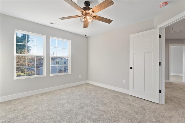 carpeted spare room featuring ceiling fan