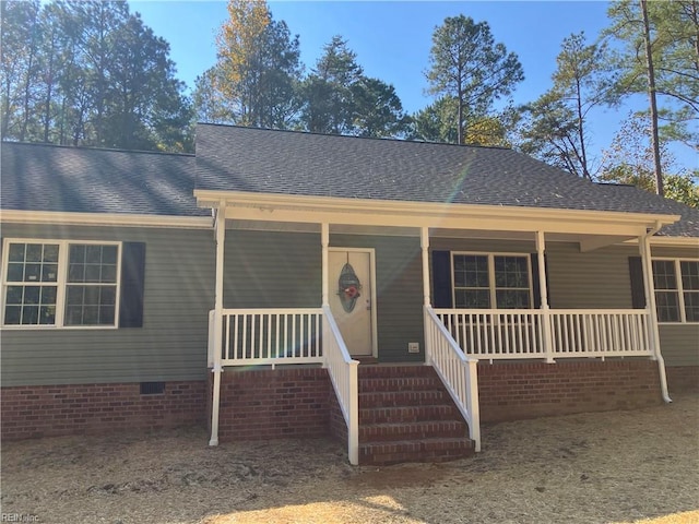 view of front of house featuring crawl space, covered porch, and a shingled roof