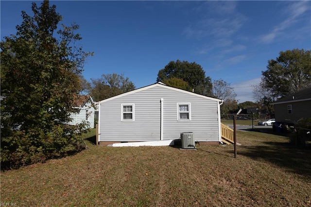 view of property exterior with central AC and a yard