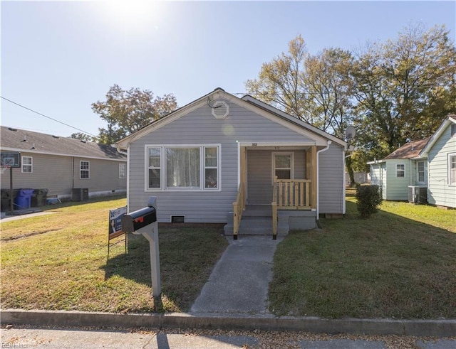 bungalow-style house featuring a front lawn, central AC unit, and a porch