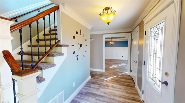 foyer entrance with crown molding and hardwood / wood-style flooring