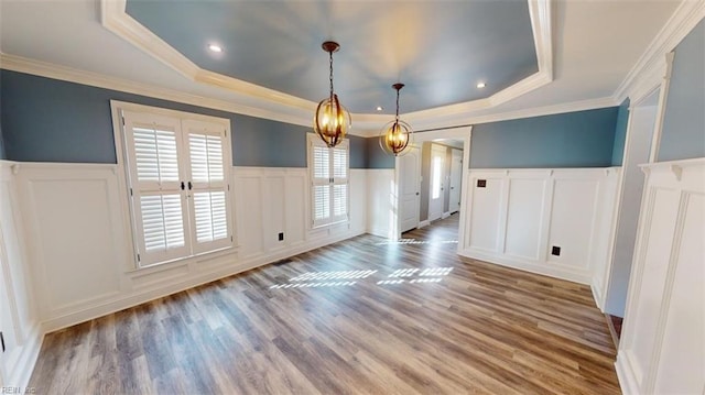 unfurnished dining area featuring ornamental molding, french doors, hardwood / wood-style flooring, and a raised ceiling