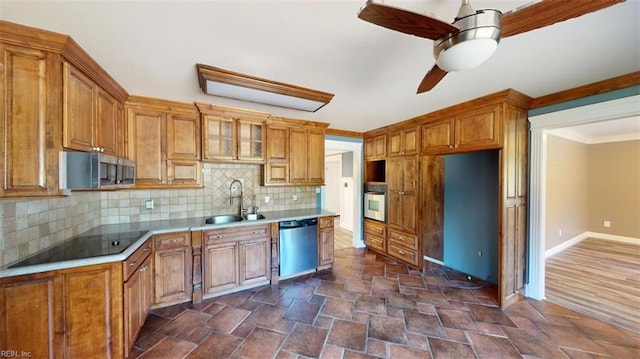 kitchen with tasteful backsplash, sink, ceiling fan, stainless steel appliances, and ornamental molding