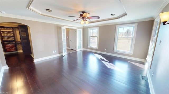 interior space featuring crown molding, dark hardwood / wood-style floors, and a raised ceiling