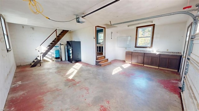 interior space with a garage door opener and black refrigerator