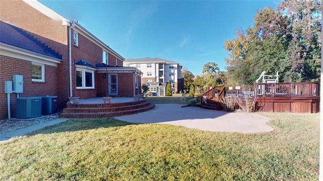 view of yard featuring a deck, a patio, and central AC unit