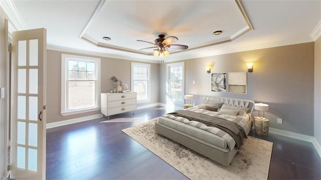 bedroom featuring crown molding, dark wood-type flooring, a raised ceiling, and ceiling fan