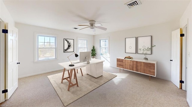 carpeted home office featuring ceiling fan