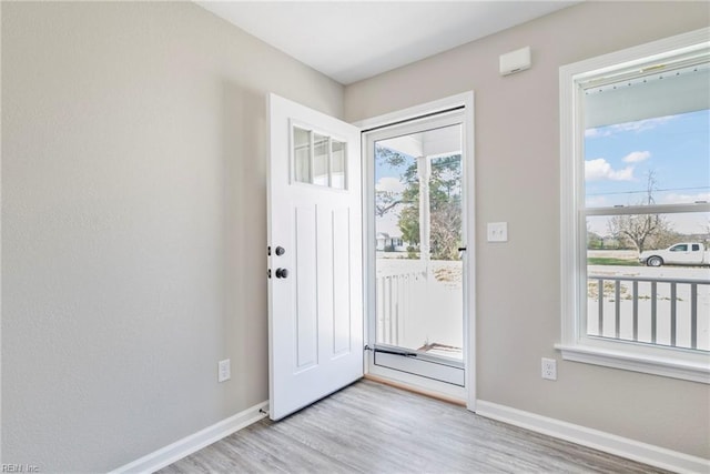 doorway featuring baseboards and wood finished floors