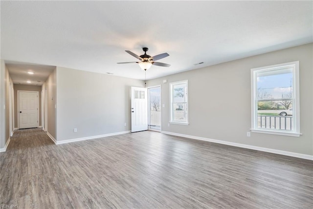 spare room with dark wood-type flooring and ceiling fan