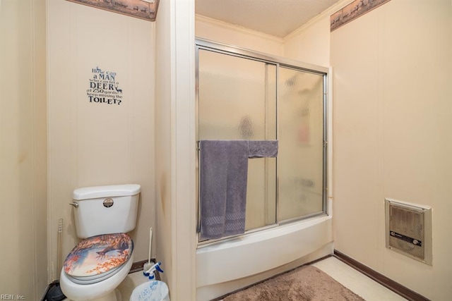 bathroom featuring toilet, combined bath / shower with glass door, and heating unit